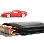 Photo of a red car near a black wallet